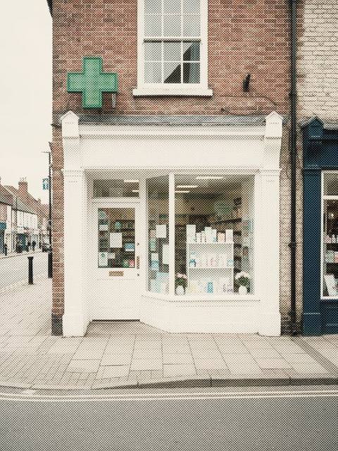 A pharmacy shopfront with a green cross